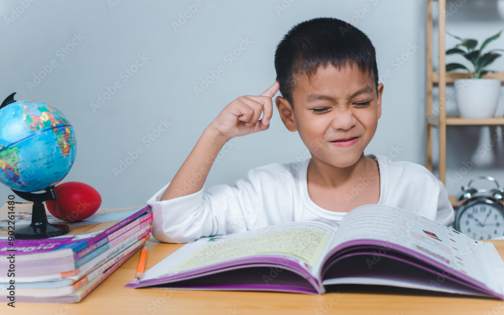 The child smile thinking sitting at table with book. Education, Childhood, People, Homework and school concept. Student learning study reading book while sitting at home. The child smile thinking sitting at table with book. Education, Childhood, People, Homework and school concept. Student learning study reading book while sitting at home.