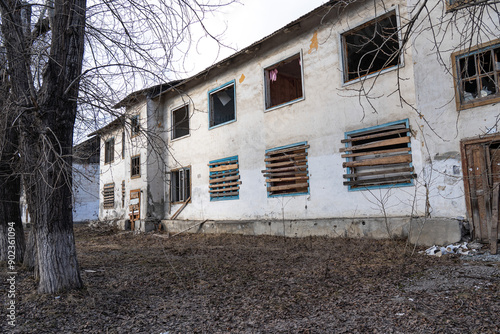 Boarded up windows. An old abandoned wooden house with boarded up windows and a crumbling roof