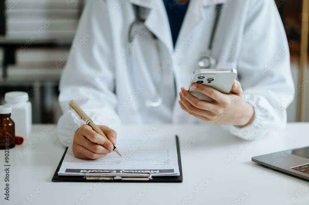 Fototapeta premium Medical technology concept. Doctor working with mobile phone and stethoscope and digital tablet laptop in modern office at hospital 