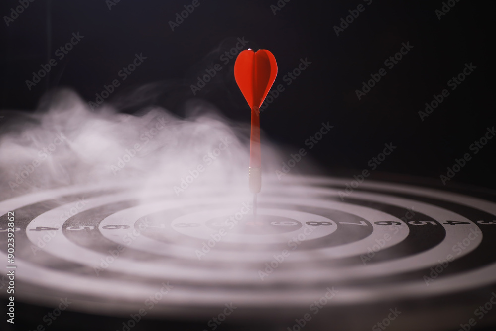 Red Dart on Bullseye Target Surrounded by Smoke - Precision, Focus, and Success Concept Red Dart on Bullseye Target Surrounded by Smoke - Precision, Focus, and Success Concept