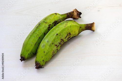 Two fresh green banana or raw banana on wooden background. photo