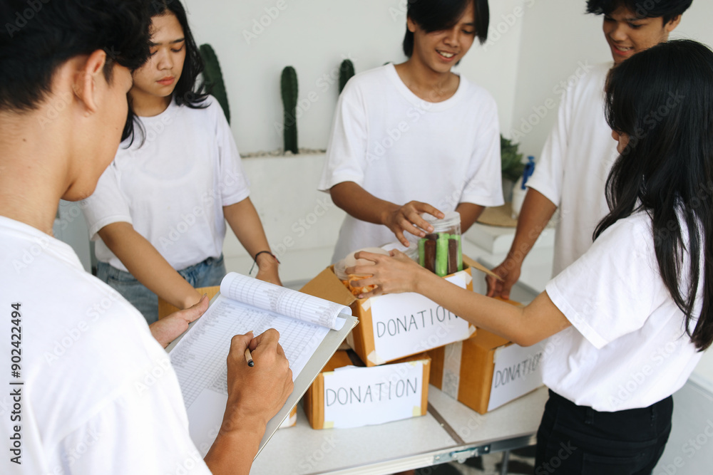 Obraz premium Preparation for Charity Event. Humanitarian Activist Packing Food for Donation.
