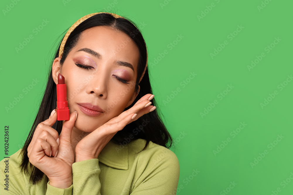 Beautiful Asian woman with lipstick on green background Beautiful Asian woman with lipstick on green background