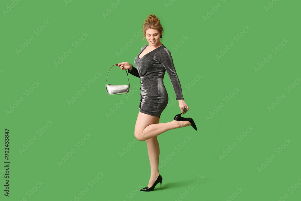 Beautiful young woman in stylish dress with handbag on green background Beautiful young woman in stylish dress with handbag on green background