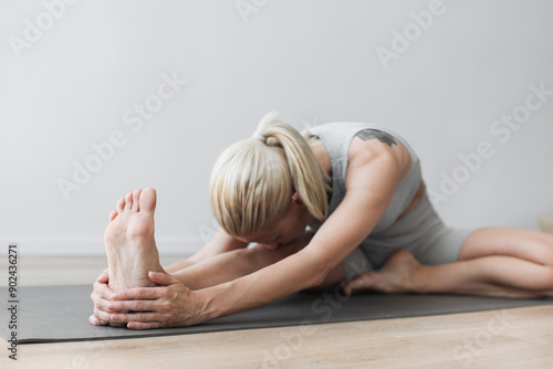 Young woman practicing yoga in yoga studio. Young beautiful girl doing exercises at home. Harmony, balance, meditation, relaxation, healthy lifestyle concept