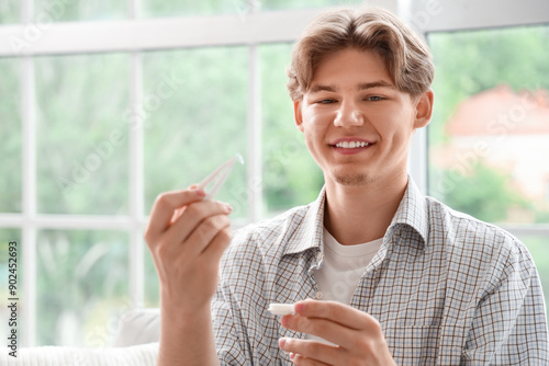 Free Download Young man with tweezers taking contact lenses at home, closeup - GFXLoad