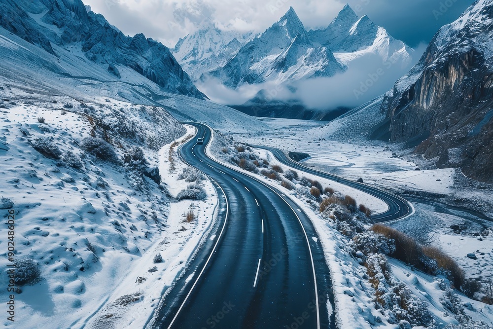 Drone shot of a winding mountain road through a snowy landscape. Drone shot of a winding mountain road through a snowy landscape.