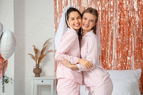 Happy young women in pajama...