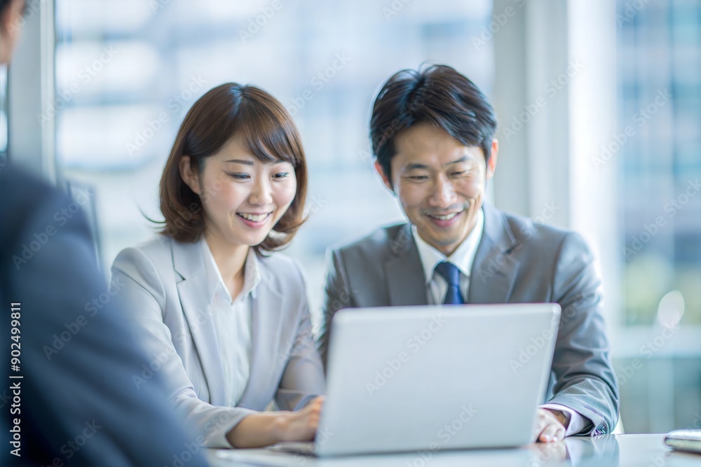 ラップトップで共同作業する日本人の同僚
ラップトップで共同作業する日本人の同僚