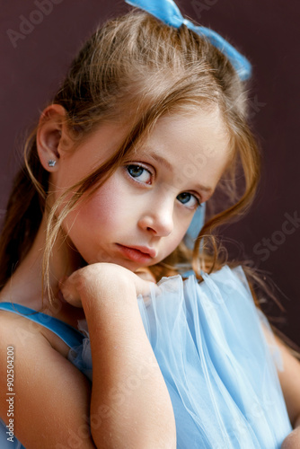 close-up portrait of a charming little girl kid 5-6 years old in a blue tulle dress. Fashion kid portrait outdoor