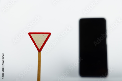 Wooden Yield Sign with Blurred Smartphone photo