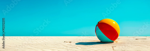 Beach ball on sand and blue sky in the background