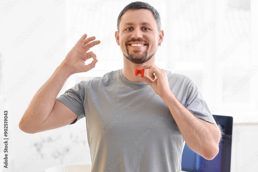 Young man with thyroid gland model showing OK at endocrinologist's office Young man with thyroid gland model showing OK at endocrinologist's office