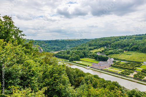 Panoramic aerial view of Freyr Castle in Renaissance style, French style gardens, Meuse river and hill with leafy trees in background, cloudy summer day in Namur province, Wallonia, Belgium photo