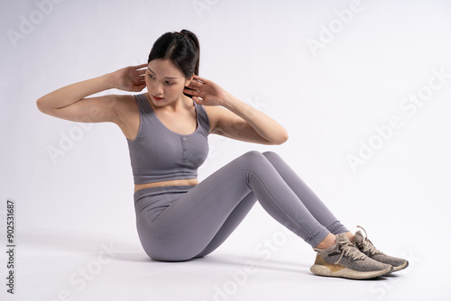 Portrait of Asian woman wearing sportswear, posing on white background.