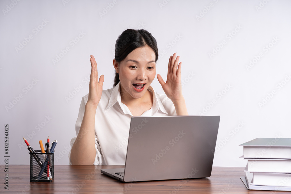 Young female businessman sitting at desk on white background Young female businessman sitting at desk on white background