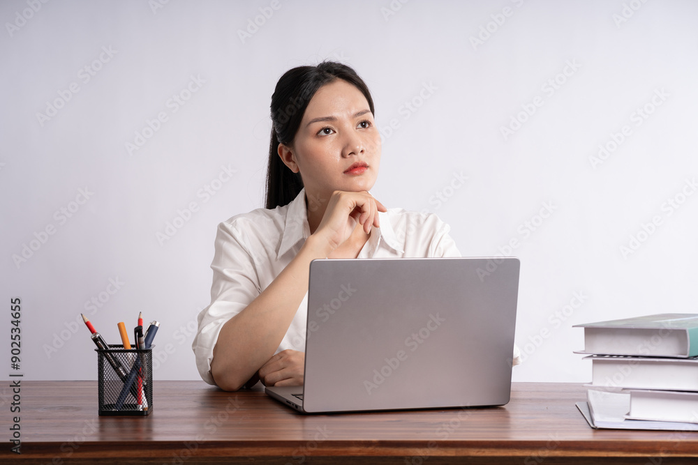 Young female businessman sitting at desk on white background Young female businessman sitting at desk on white background