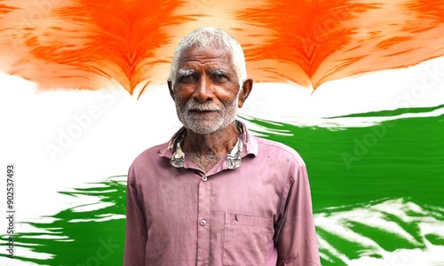 Portrait of an Indian old villager man smiling and looking at camera behind tri color background.