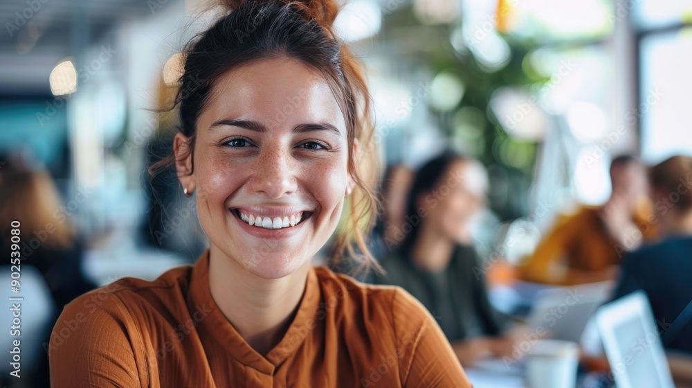 A smiling woman sits at a table with a laptop, focused on her work A smiling woman sits at a table with a laptop, focused on her work