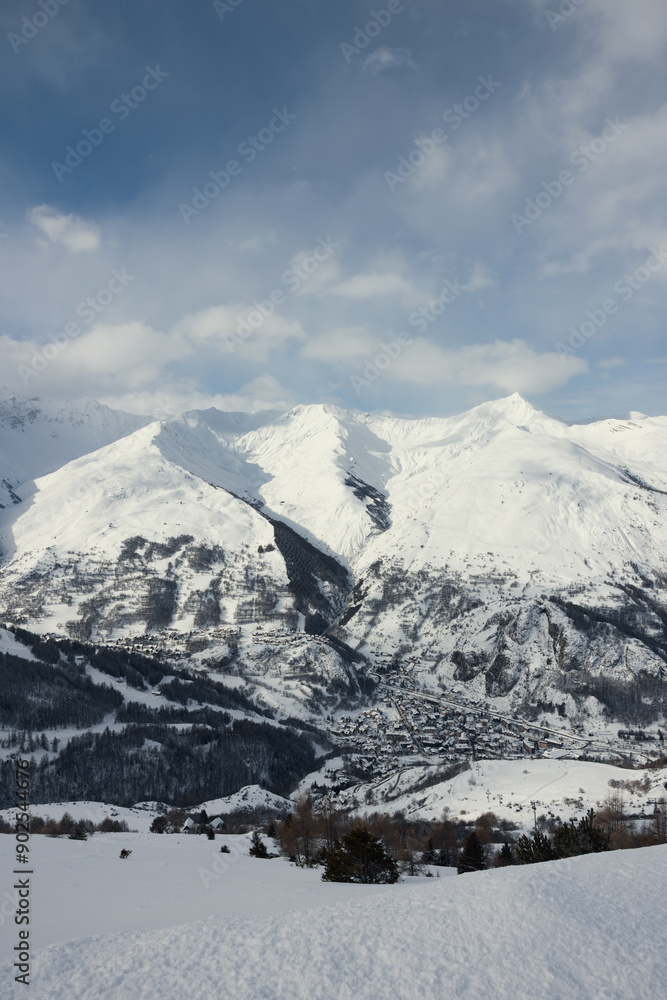 Obraz premium Small village nestled between enormous snowy mountains