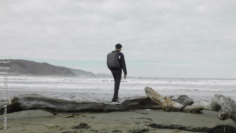 A Malaysian Photographer Standing on the Seashore at Lyall Bay in Wellington, New Zealand - Wide Shot A Malaysian Photographer Standing on the Seashore at Lyall Bay in Wellington, New Zealand - Wide Shot