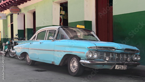 Front and side view, white-roofed blue American classic car -Chevrolet from 1959- parked on 707 Calle Hartmann Street, east side. Santiago-Cuba-526 photo