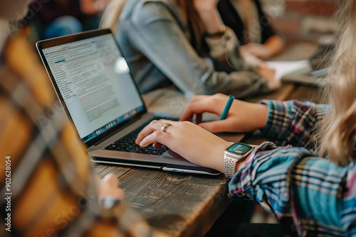 Students working on laptops and taking notes in a collaborative study session.