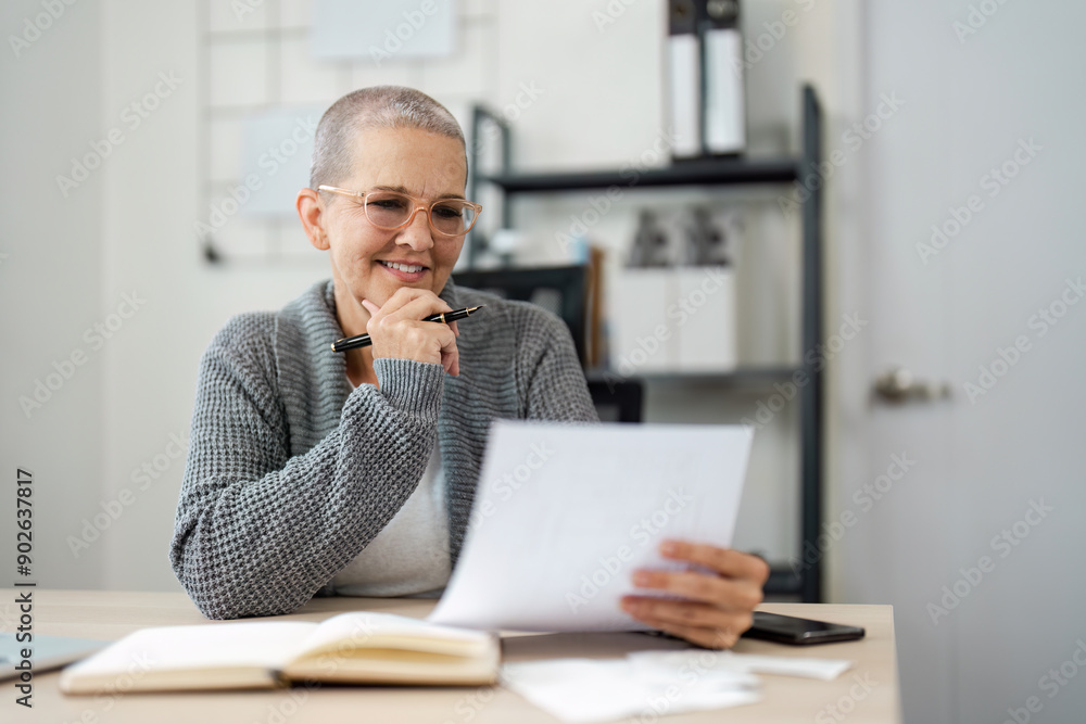 Senior Woman Reviewing Financial Documents and Planning for Saving at Home Office Senior Woman Reviewing Financial Documents and Planning for Saving at Home Office