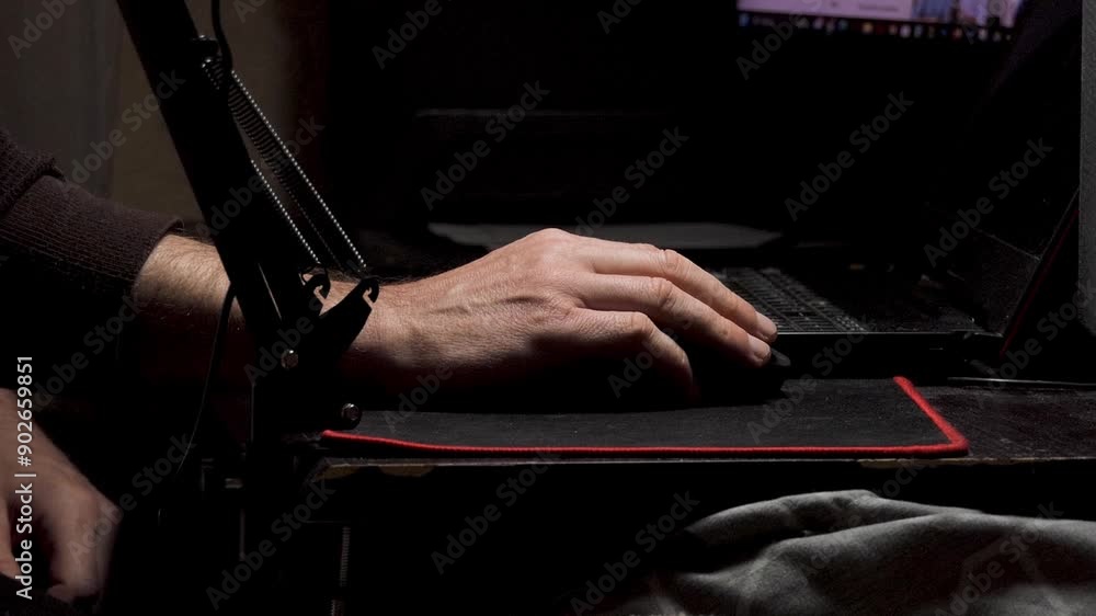 A man works sitting at a table, moving the mouse on a laptop A man works sitting at a table, moving the mouse on a laptop