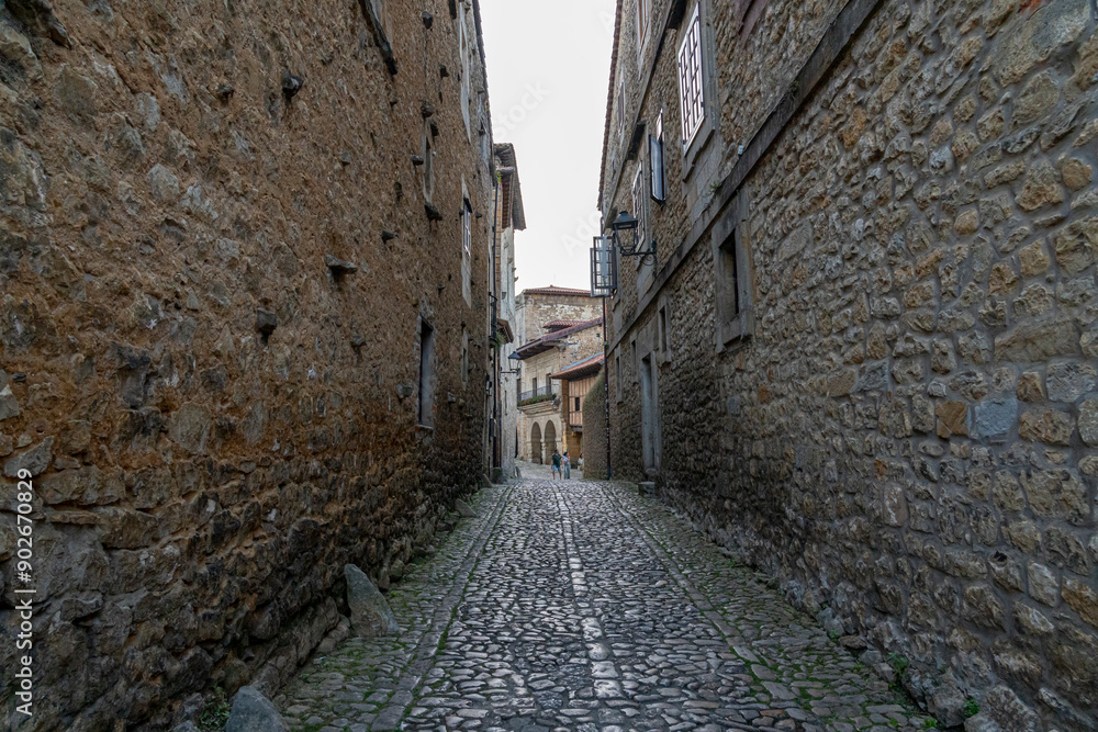 Quaint narrow alley with stone-paved path and historic buildings in Santillana del Mar, Spain. Perfect for travel, architecture, and cultural themes Quaint narrow alley with stone-paved path and historic buildings in Santillana del Mar, Spain. Perfect for travel, architecture, and cultural themes
