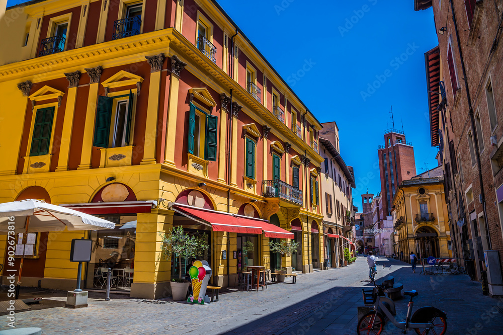 Fototapeta premium A view down a side street leading away from the cathedral of Saint Cassian the Martyr in Imola, Italy in summertime