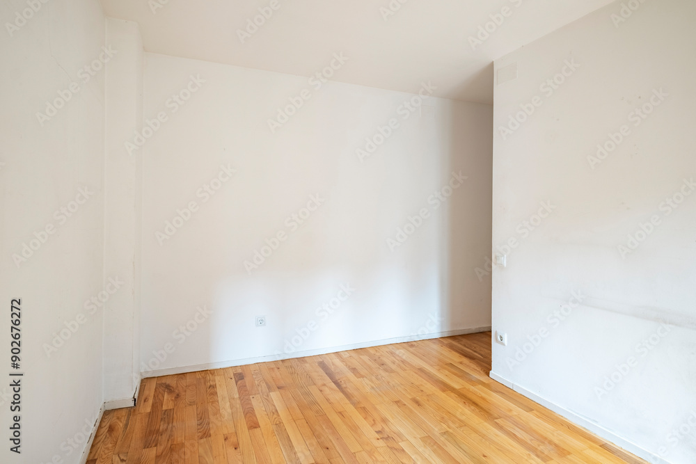 Fototapeta premium A spacious empty room featuring wooden floors and white walls, offering a clean and open space ready to be furnished according to the desired style and purpose.