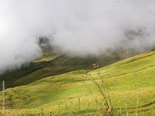 White clouds very close to the mountain meadow. Magic view with shadows photo