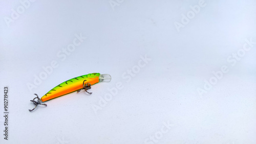 Close up green tiger minnow fishing lure with treble hook on isolated white background.