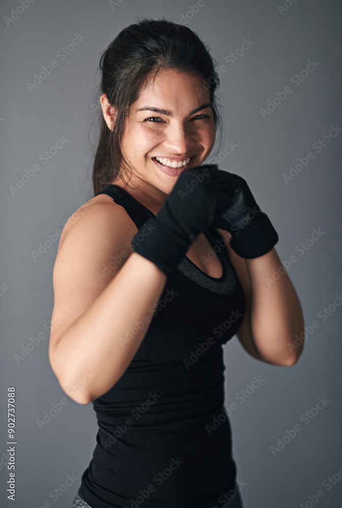 Woman, portrait and fist in studio for training, cardio boxing and ready for fight tournament with power. Girl, happy and gray background for self defense with wellness, combat workout and endurance. Woman, portrait and fist in studio for training, cardio boxing and ready for fight tournament with power. Girl, happy and gray background for self defense with wellness, combat workout and endurance.