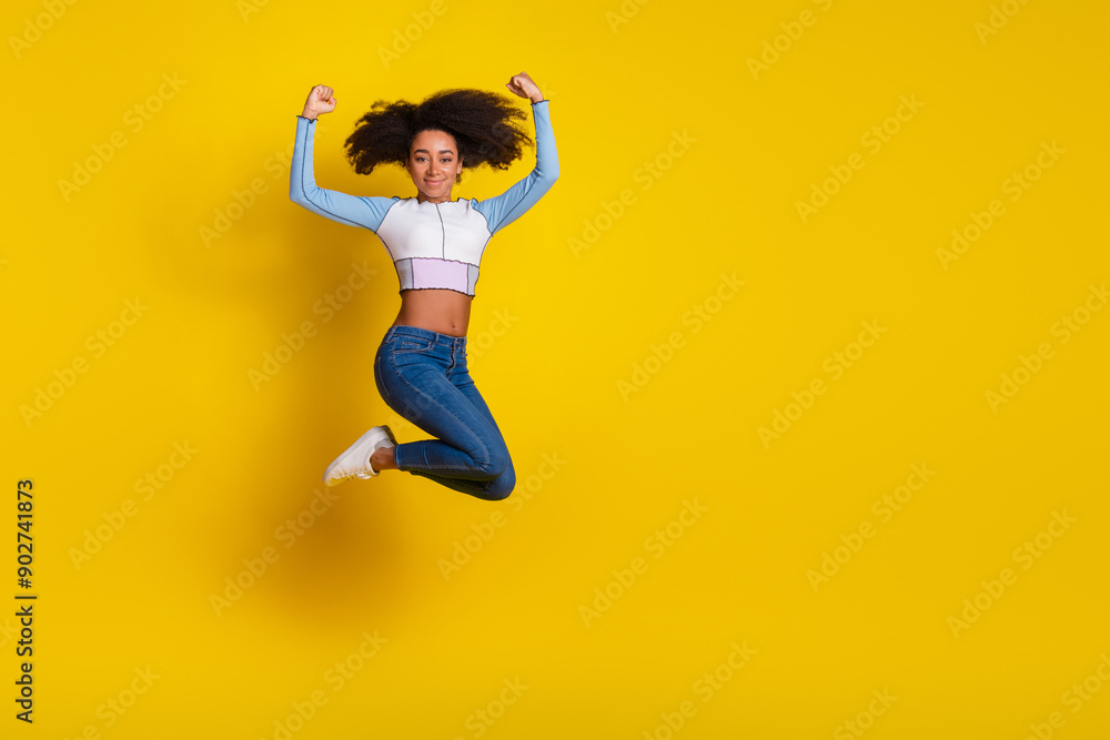 Full size photo of pretty young girl winning jumping wear trendy blue outfit isolated on yellow color background Full size photo of pretty young girl winning jumping wear trendy blue outfit isolated on yellow color background