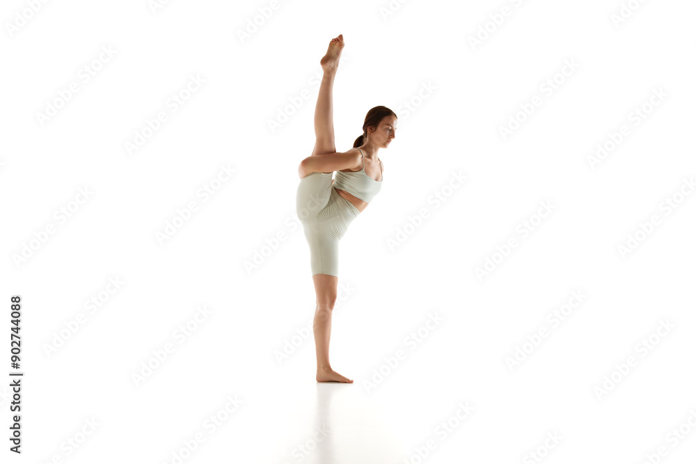 Fit woman in athletic wear performs one-legged downward dog yoga pose demonstrating her balance against white studio background. Concept of beauty, mindfulness, mental health, concentration. Ad Fit woman in athletic wear performs one-legged downward dog yoga pose demonstrating her balance against white studio background. Concept of beauty, mindfulness, mental health, concentration. Ad