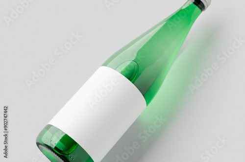 Green glass water bottle mockup with a blank label, closeup. photo