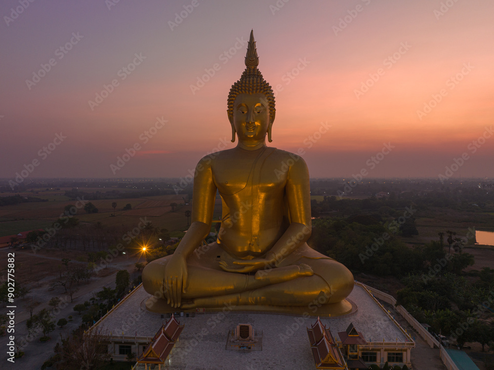scenery sunset behind the great golden Buddha landmark of Thailand at wat Muang Ang Thong Thailand. .The largest Buddha statue in the world Surrounded by rice fields..colorful sky background. scenery sunset behind the great golden Buddha landmark of Thailand at wat Muang Ang Thong Thailand. .The largest Buddha statue in the world Surrounded by rice fields..colorful sky background.