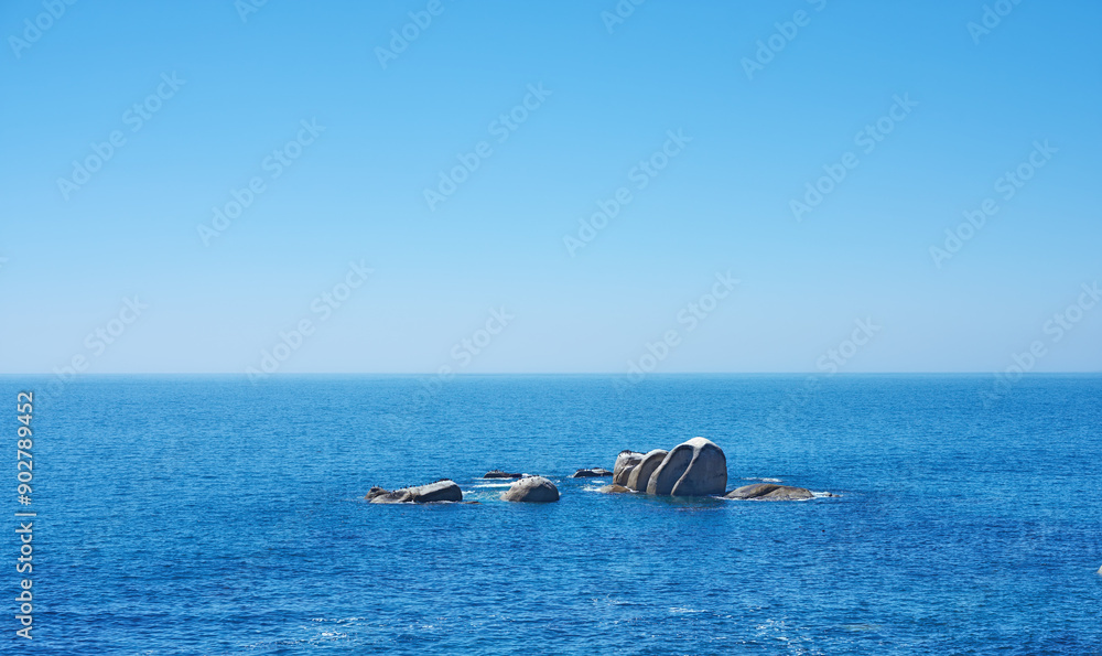 Fototapeta premium Ocean, rocks and horizon in outdoor location, travel and peace in environment on sea vacation. Water, stone and calm beach on weekend trip, tropical island and holiday wallpaper of Caribbean skyline