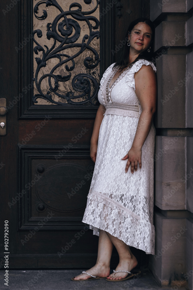 Naklejka premium woman in a white lace dress stands in front of a door