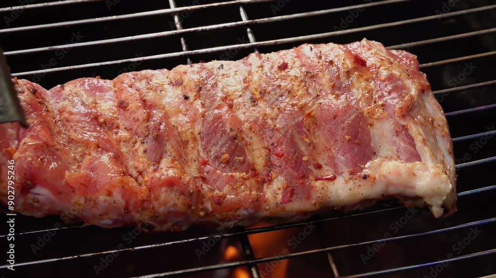 Half-prepared delicious ribs are flipped on the grill grid with kitchen tongs on the background of the open fire. High quality 4k footage Half-prepared delicious ribs are flipped on the grill grid with kitchen tongs on the background of the open fire. High quality 4k footage