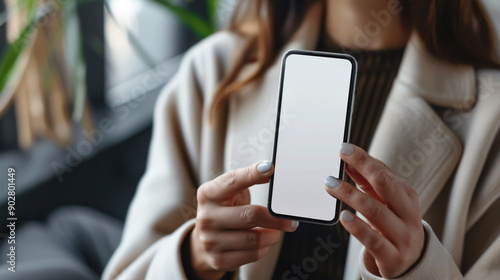 Mockup image of a woman holding a white mobile phone with a blank desktop screen and an empty white business card.