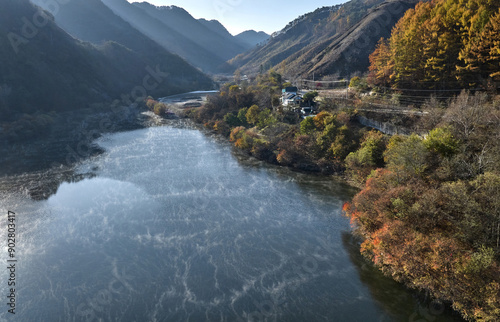 Aerial and atumnal view of water fog on Soyangho Lake and maple trees with house and road at Namjeon-ri near Inje-gun, South Korea
 photo