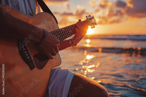 Fototapeta Naklejka Na Ścianę i Meble -  Close up young man playing guitar at sunset at the beach. Relaxed beautiful man playing guitar at beach