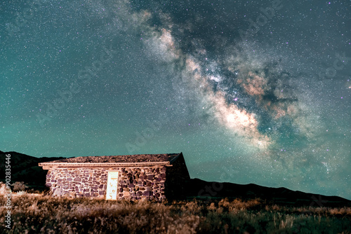 Milky Way over a vintage, stone cabin in the desert