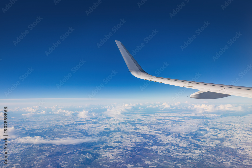 Airplane flying over color sky clouds during scenic sunset or sunrise cloudscape, view from plane window of wing turbines and horizon Airplane flying over color sky clouds during scenic sunset or sunrise cloudscape, view from plane window of wing turbines and horizon