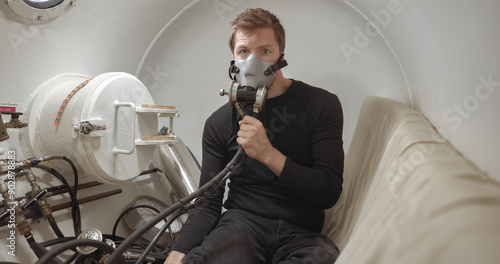 Military man receiving treatment in industrial hyperbaric chamber