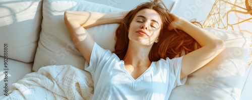 Woman napping on a cozy couch, soft blankets, warm natural light, high-angle view, tranquil living room photo