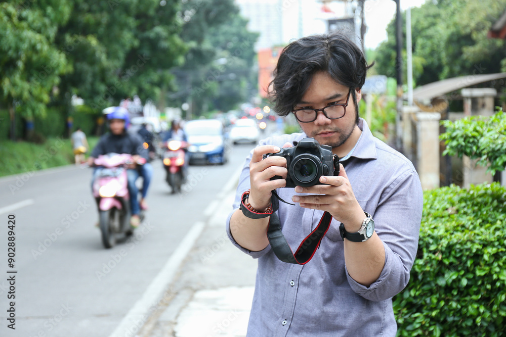 a male photographer shoots the object he is going to take located on a city street a male photographer shoots the object he is going to take located on a city street